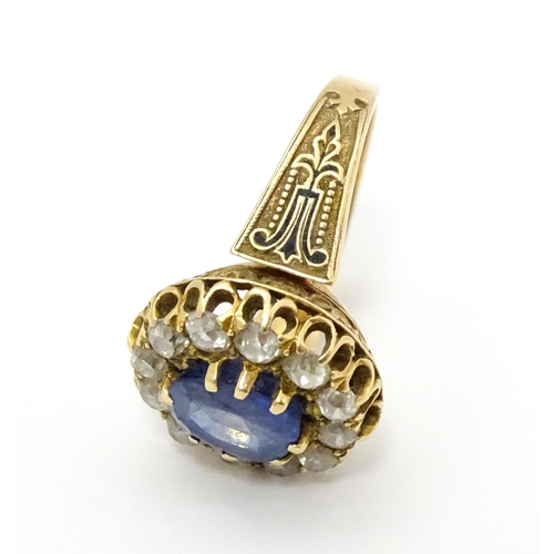 731 - A late 19thC / early 20thC gold ring set with central sapphire bordered by twelve diamonds flanked b... 