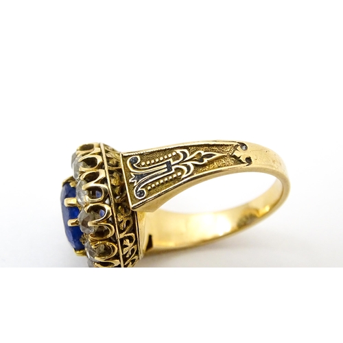 731 - A late 19thC / early 20thC gold ring set with central sapphire bordered by twelve diamonds flanked b... 