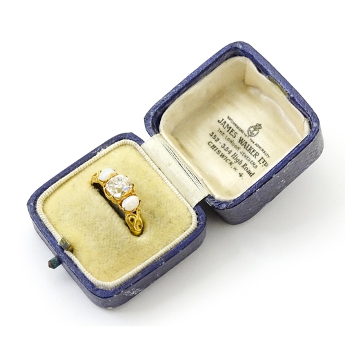 733 - A late 19thC / early 20thC gold ring set with central diamond flanked by opals. The central diamond ... 