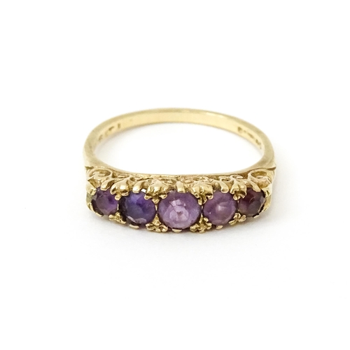 734 - A 9ct gold ring set with 5 graduated amethysts. Ring size approx. P