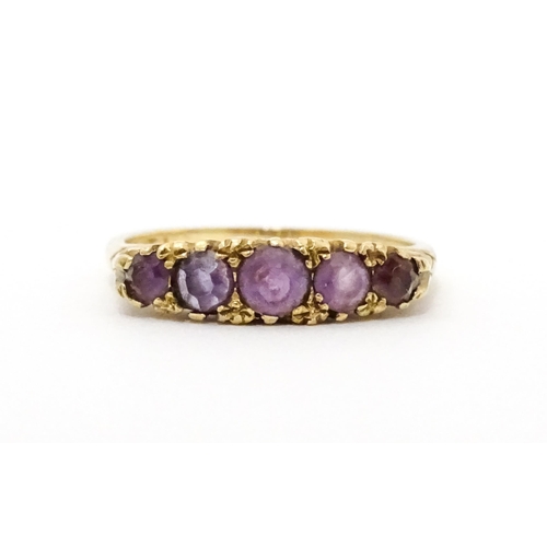 734 - A 9ct gold ring set with 5 graduated amethysts. Ring size approx. P