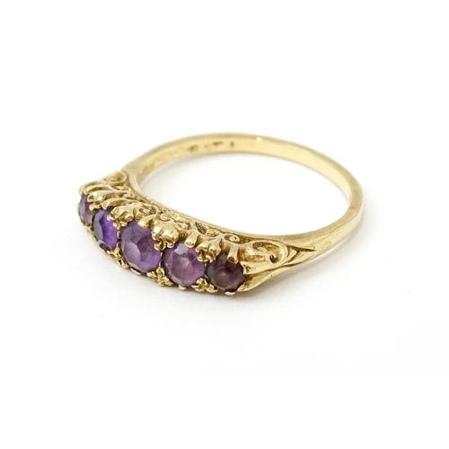 734 - A 9ct gold ring set with 5 graduated amethysts. Ring size approx. P