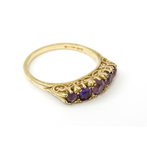 734 - A 9ct gold ring set with 5 graduated amethysts. Ring size approx. P