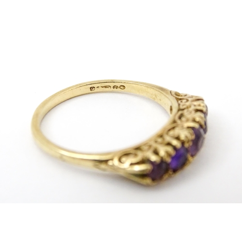 734 - A 9ct gold ring set with 5 graduated amethysts. Ring size approx. P