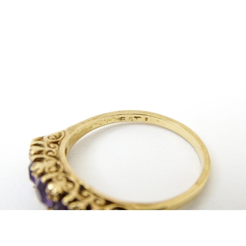 734 - A 9ct gold ring set with 5 graduated amethysts. Ring size approx. P