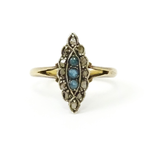 735 - A late 19thC / early 20thC 18ct gold ring set with three blue stones bordered by diamonds. Ring size... 