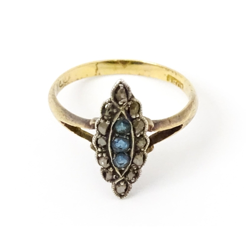 735 - A late 19thC / early 20thC 18ct gold ring set with three blue stones bordered by diamonds. Ring size... 