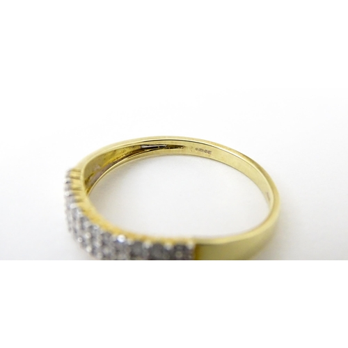 736 - A 9ct gold ring set with three bands of diamonds. Ring size approx. R 1/2