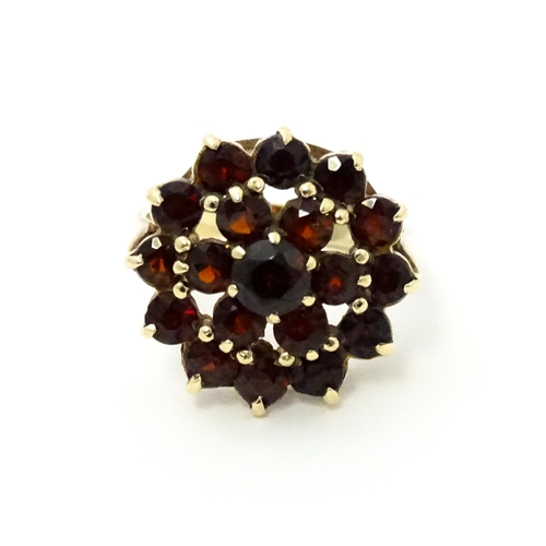 740 - A 9ct gold cocktail ring set with 19 garnets in a cluster setting. Ring size approx. O