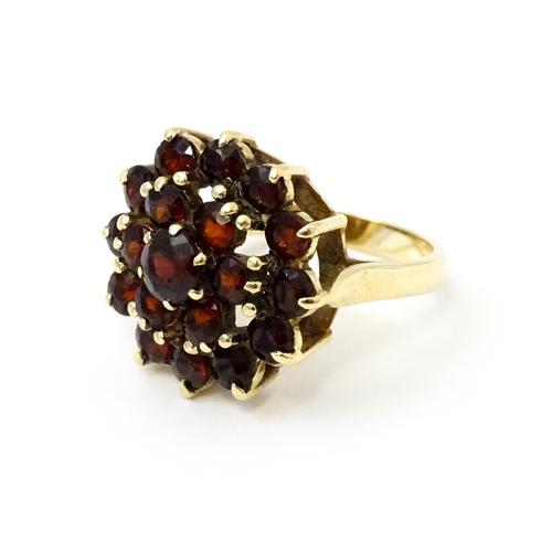 740 - A 9ct gold cocktail ring set with 19 garnets in a cluster setting. Ring size approx. O