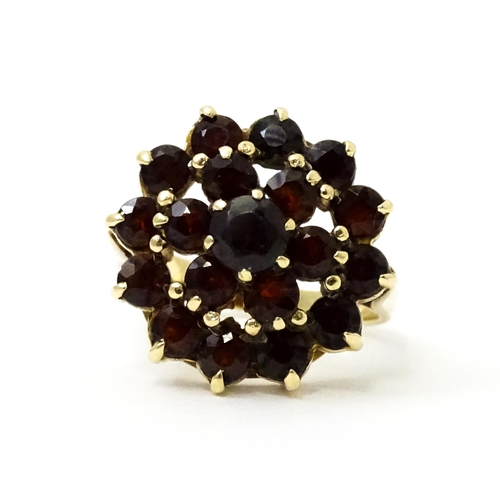 740 - A 9ct gold cocktail ring set with 19 garnets in a cluster setting. Ring size approx. O