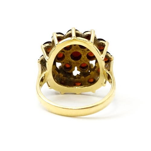 740 - A 9ct gold cocktail ring set with 19 garnets in a cluster setting. Ring size approx. O