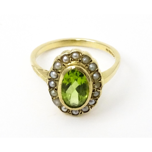 741 - A 9ct gold ring set with central peridot bordered by seed pearls. Ring size approx. P