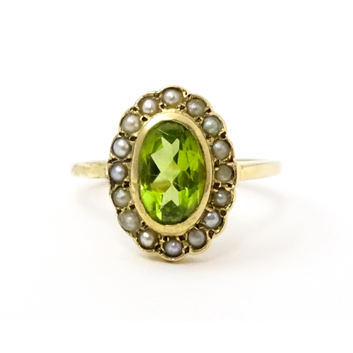 741 - A 9ct gold ring set with central peridot bordered by seed pearls. Ring size approx. P