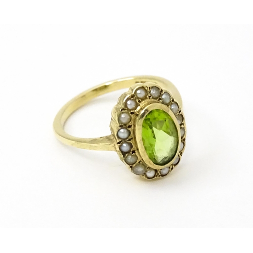 741 - A 9ct gold ring set with central peridot bordered by seed pearls. Ring size approx. P