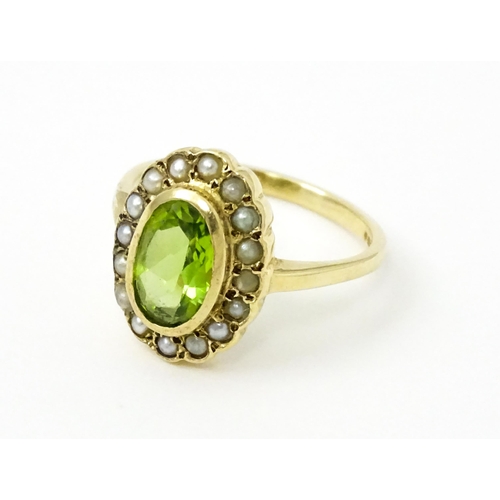 741 - A 9ct gold ring set with central peridot bordered by seed pearls. Ring size approx. P