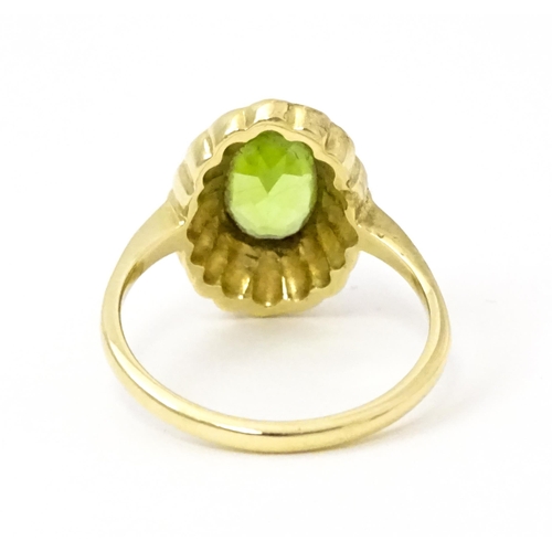 741 - A 9ct gold ring set with central peridot bordered by seed pearls. Ring size approx. P