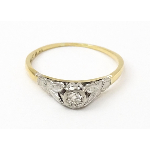 746 - An 18ct gold ring with central platinum set brilliant cut diamond. Ring size approx. O 1/2