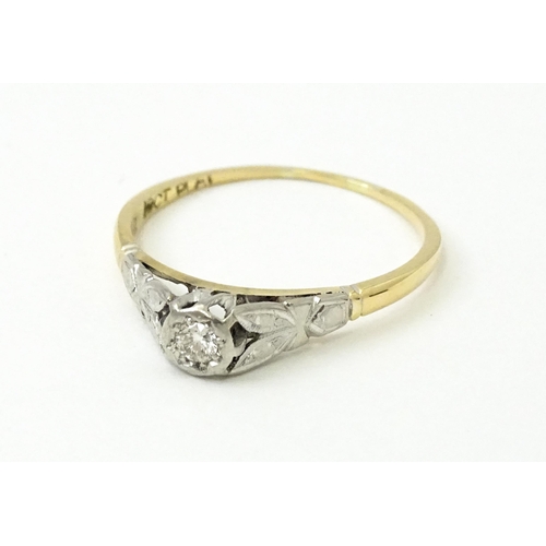 746 - An 18ct gold ring with central platinum set brilliant cut diamond. Ring size approx. O 1/2