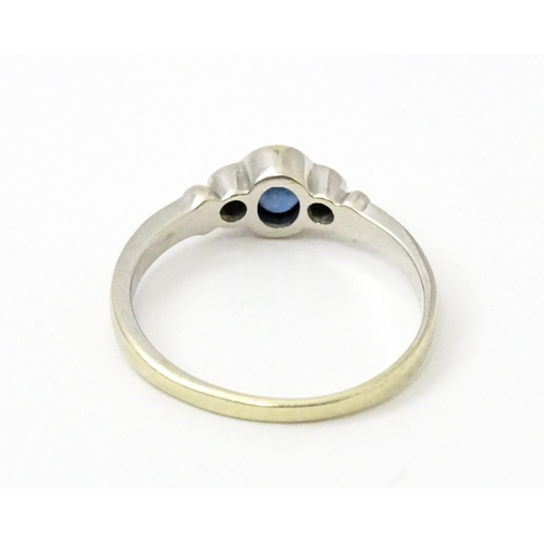 747 - A 9ct white gold ring set with central sapphire flanked by diamonds. Maker Alfred Terry Ltd  Ring si... 