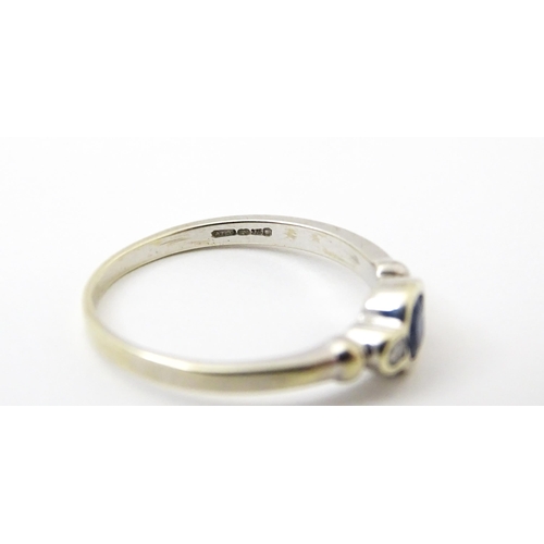 747 - A 9ct white gold ring set with central sapphire flanked by diamonds. Maker Alfred Terry Ltd  Ring si... 