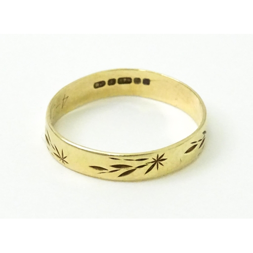 748 - A 9ct gold ring with engraved decoration. Ring size approx. P. (Approx. 1.5g)