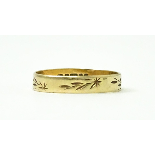 748 - A 9ct gold ring with engraved decoration. Ring size approx. P. (Approx. 1.5g)