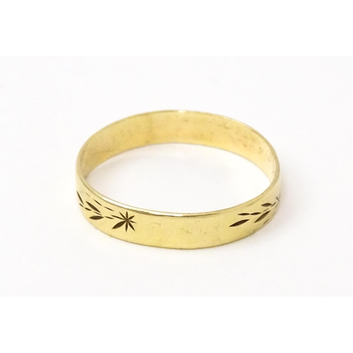 748 - A 9ct gold ring with engraved decoration. Ring size approx. P. (Approx. 1.5g)