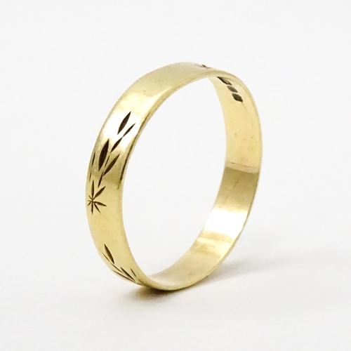 748 - A 9ct gold ring with engraved decoration. Ring size approx. P. (Approx. 1.5g)