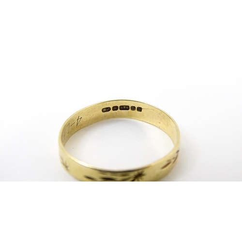 748 - A 9ct gold ring with engraved decoration. Ring size approx. P. (Approx. 1.5g)