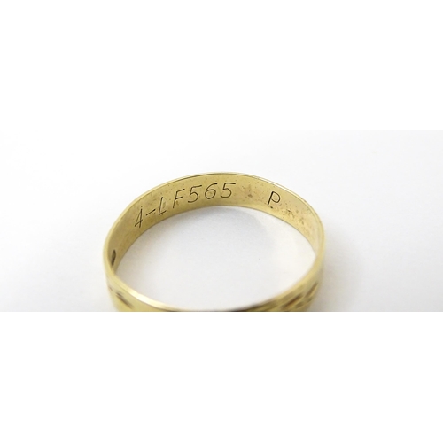 748 - A 9ct gold ring with engraved decoration. Ring size approx. P. (Approx. 1.5g)