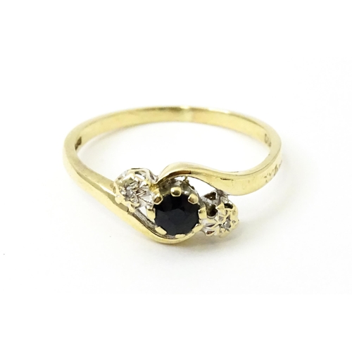 749 - A 9ct gold ring set with central sapphire flanked by diamonds. Ring size approx. Q 1/2