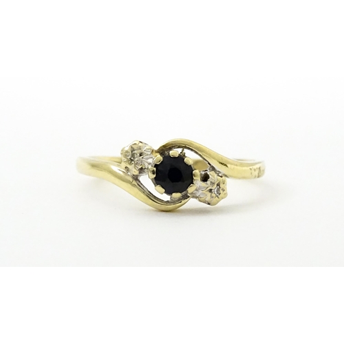 749 - A 9ct gold ring set with central sapphire flanked by diamonds. Ring size approx. Q 1/2