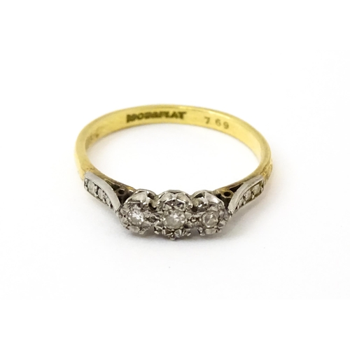 750 - An 18ct gold ring with three platinum set illusion set diamonds. Ring size approx. P 1/2