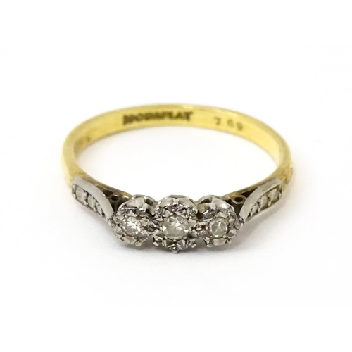 750 - An 18ct gold ring with three platinum set illusion set diamonds. Ring size approx. P 1/2