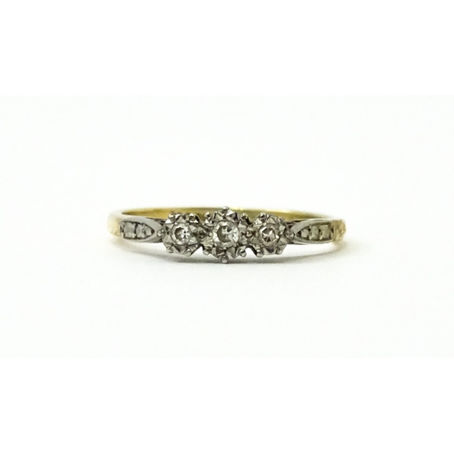 750 - An 18ct gold ring with three platinum set illusion set diamonds. Ring size approx. P 1/2