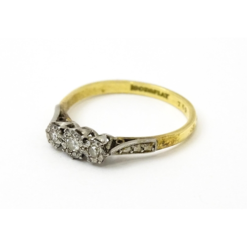 750 - An 18ct gold ring with three platinum set illusion set diamonds. Ring size approx. P 1/2