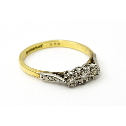 750 - An 18ct gold ring with three platinum set illusion set diamonds. Ring size approx. P 1/2