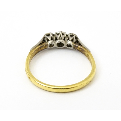 750 - An 18ct gold ring with three platinum set illusion set diamonds. Ring size approx. P 1/2