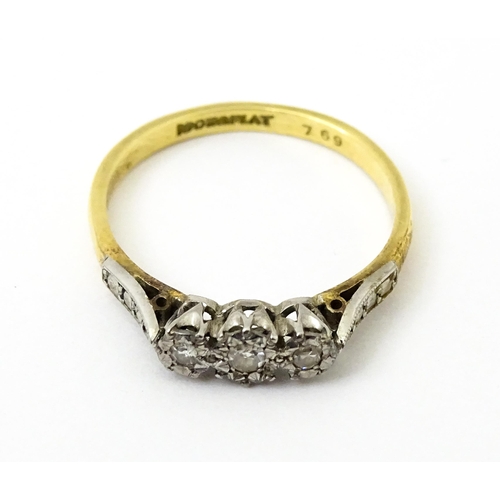 750 - An 18ct gold ring with three platinum set illusion set diamonds. Ring size approx. P 1/2