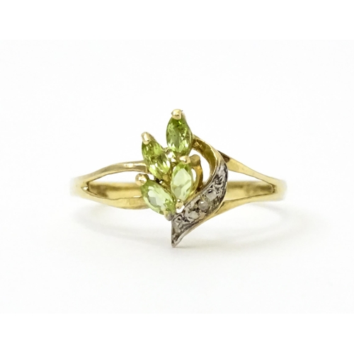 751 - A 9ct gold ring set with peridot and diamonds in a floral setting. Ring size approx. N