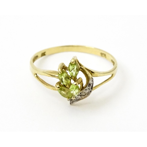 751 - A 9ct gold ring set with peridot and diamonds in a floral setting. Ring size approx. N