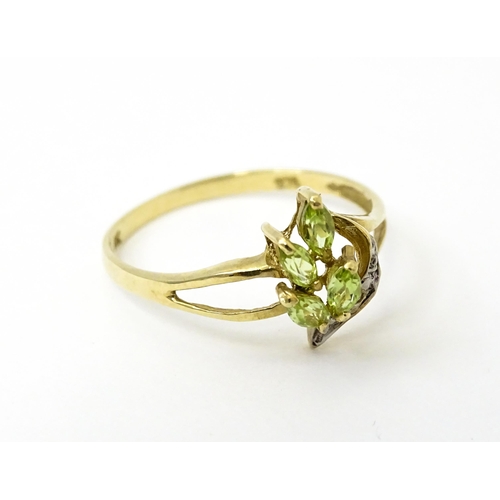 751 - A 9ct gold ring set with peridot and diamonds in a floral setting. Ring size approx. N