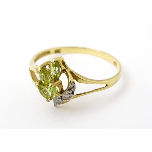 751 - A 9ct gold ring set with peridot and diamonds in a floral setting. Ring size approx. N