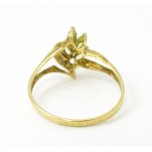 751 - A 9ct gold ring set with peridot and diamonds in a floral setting. Ring size approx. N