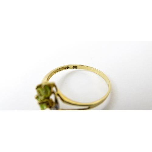 751 - A 9ct gold ring set with peridot and diamonds in a floral setting. Ring size approx. N