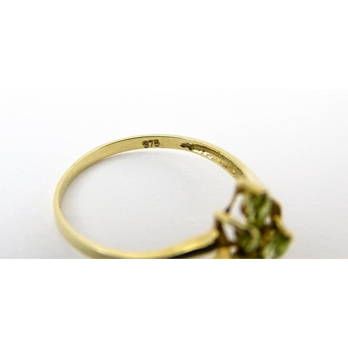 751 - A 9ct gold ring set with peridot and diamonds in a floral setting. Ring size approx. N