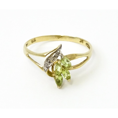 751 - A 9ct gold ring set with peridot and diamonds in a floral setting. Ring size approx. N