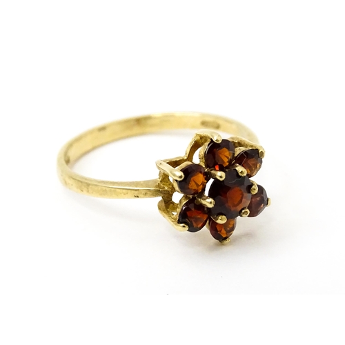 753 - A 9ct gold ring set with garnets in a floral setting. Ring size approx. O