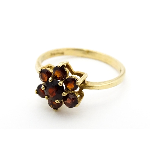 753 - A 9ct gold ring set with garnets in a floral setting. Ring size approx. O